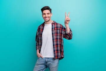 Sticker - Photo of positive good mood guy wear checkered shirt showing v-sign isolated blue teal color background