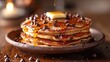 A stack of chocolate chip pancakes, drizzled with syrup and topped with a pat of butter, located on the left side, with a warm-colored background on the right half for text