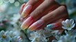 A woman's hands with nails featuring a gradient of spring colors, from soft pinks to fresh greens, each fingertip adorned with tiny painted blossoms, positioned against a dreamy background