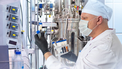 Poster - doctor near bioreactor. man medic with blood test tubes. doctor works with medical equipment. biorea