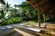 Empty yoga mats on a wooden deck surrounded by lush tropical greenery
