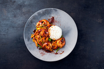 Wall Mural - Traditional Thai fried king prawns with vegetable, mango and rice served as top view on a design plate with text space