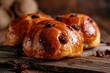 Sweet buns with raisins on a dark wooden background.