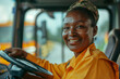 © Simn - Bus driver, African-American working woman behind the wheel with a charming smile in a school bus with copy space