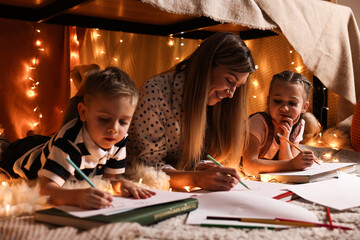 Canvas Print - Mother and her children drawing in play tent at home