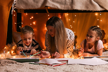 Canvas Print - Mother and her children drawing in play tent at home