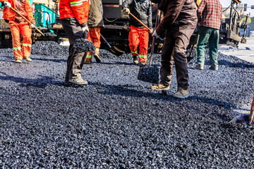 Wall Mural - Teamwork, Workers laying asphalt road at construction site.