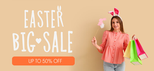 Wall Mural - Young woman in bunny ears with shopping bags and paper rabbit on beige background. Easter celebration