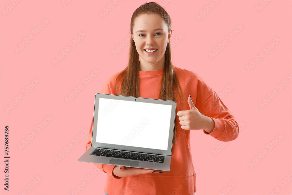 Female programmer with laptop showing thumb-up on pink background