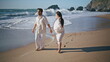 Pregnant family enjoying walk ocean shore smiling. Couple awaiting baby on beach