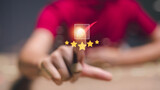 Fototapeta Desenie - A person is pointing at a star rating system with a red background