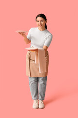 Wall Mural - Beautiful young waitress with plates on pink background