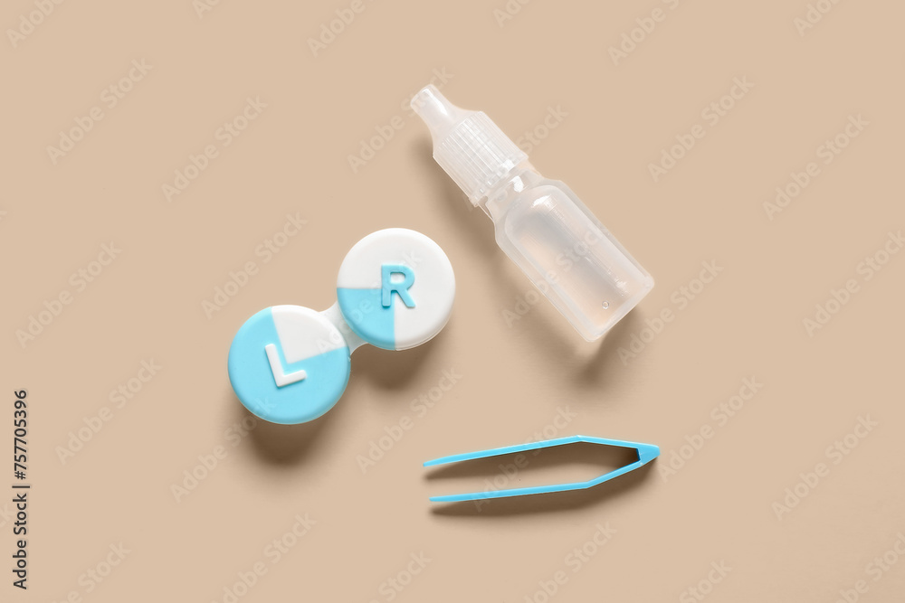 Tweezers with solution and container for contact lenses on beige background