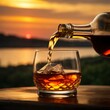 Cognac being poured into a glass against the backdrop of a sunset on Cognac Day
