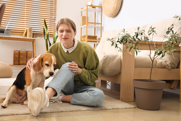 Wall Mural - Young woman with dog traumatized her knee at home