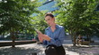 Smiling manager reading smartphone message sitting city square sunny day closeup