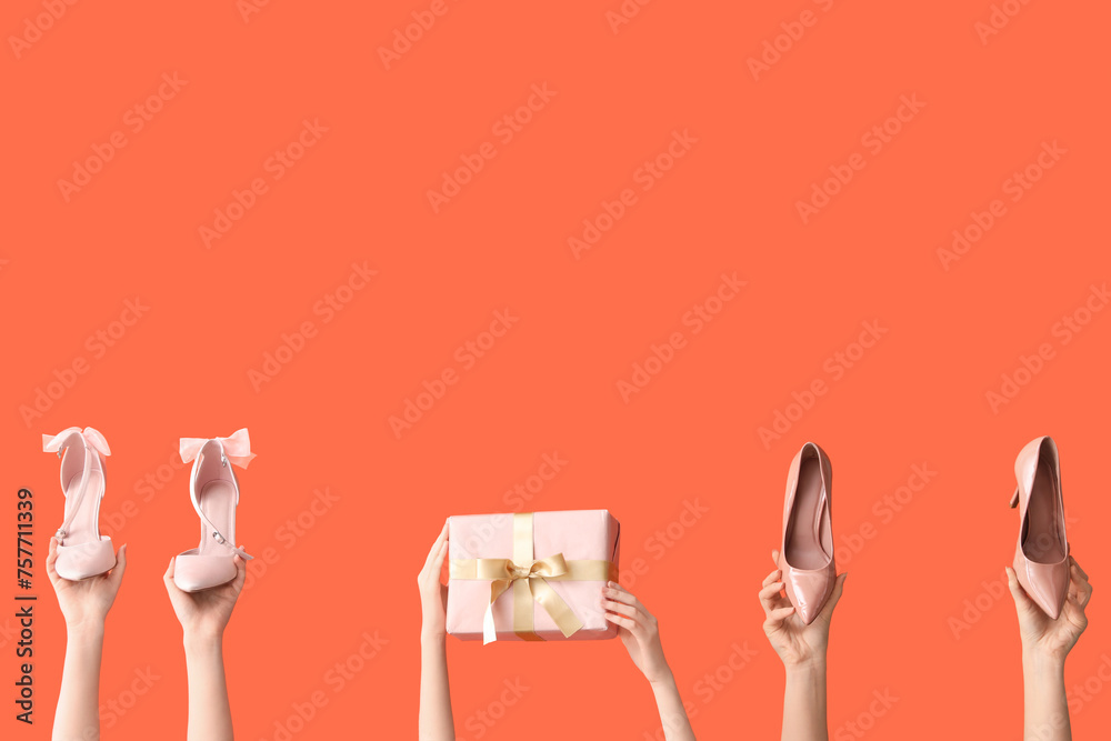 Women with stylish heels and gift box on orange background