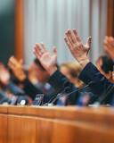 Fototapeta  - News from parliamentary meetings: voting on various issues, many hands raised in unison as a symbol of unity in decision-making.