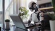 The AI robot sits at a desk, typing on a laptop. The robot appears to work in the manner of an office employee. Interaction between humans and artificial intelligence technologies.