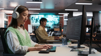 Aufkleber - Female Asian Game Programmer Coding On Desktop Computer In Game Development Studio Diverse Office. Focused Woman Writes Lines Of Code, Does Gameplay Engineering For New Immersive 3D RPG Video Game