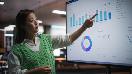 Aufkleber - Creative Office Meeting: Portrait of Beautiful Asian Female Project Manager Presenting Financial Goals For Marketing Strategy, Uses TV Set with Data Analysis, eCommerce Infographics