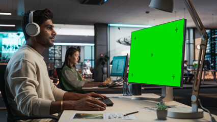 Aufkleber - Indian Male Game Designer Using Desktop Computer With Green Screen Chromakey on Display, Designing Immersive World In 3D Modelling Software For New Video Game. Man Working In Game Development Office