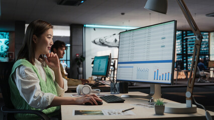 Wall Mural - Female Asian Manager Working on Desktop Computer With Analytics Reporting Software on Display in Office. Stylish Woman Analyzing Financial Data