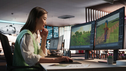 Fototapete - Female Asian Game Designer Using Desktop Computer, Designing Unique World And Characters In 3D modelling Software For RPG Video Game. Woman Working In Diverse Game Development Studio Office.