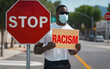 man near a stop sign with a sign, stop racism concept, equality