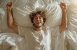 Start your day refreshed a handsome man stretches in bed, arms raised, yawning with ease