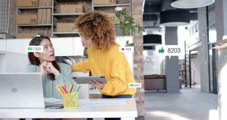 Sticker - Social media notifications over diverse female colleagues in discussion at laptop in casual office