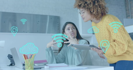 Poster - Wi fi, cloud and gps icons over diverse female colleagues in discussion at laptop in casual office