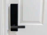 Fototapeta Tulipany - Closeup of black digital door lock handle on  white wooden door
