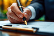 man politician signs a document contract agreement with a pen in hand at table in office close-up