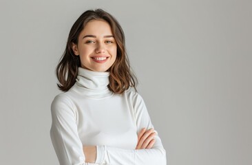 Wall Mural - A woman is smiling and wearing a white sweater. She is posing for a picture. Concept of warmth and happiness