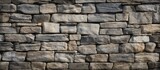 Fototapeta Do pokoju - A detailed closeup of a stone wall made of rectangular bricks, showcasing the intricate brickwork and composite material used to construct the facade