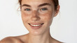 © VK Studio - Radiant woman with freckles smiling candidly on a clear background.
