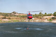 Operação aérea: Helicóptero bombeiro abastece-se em lago para enfrentar incêndio florestal