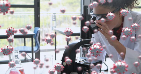 Poster - Coronavirus research depicted with cells over a female scientist using a microscope.