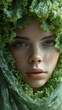 Close-up portrait of a girl with captivating eyes surrounded by vibrant green leaves, symbolizing a connection with nature.
