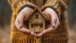 © KAYU - Hands holding a miniature house, representing the protection and assurance provided by home insurance services