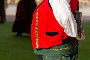 partial view of a man in traditional Galician attire at a folkloric event.