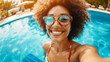 smiling afro american woman taking a selfie in the swimming pool of a luxurious all inclusive hotel