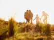 © Mariusz S/peopleimages.com - Family, nature and walk at sunset, bonding and exercise for parents and children. Lens flare, autumn and grass for hike on holiday in English countryside, mother and father for outdoor activity