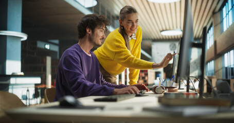 Two Young Students Studying in a College Library. Female Helping Her Classmate Male Colleague with Homework. Couple Using Desktop Computer for a Group Academic Research Project