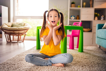 Sticker - Photo portrait of cute small girl sit floor shocked raise hands open mouth dressed stylish yellow clothes modern playroom interior