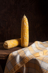 Two cobs sweet corn on wooden background..