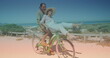 Spots of light against caucasian senior couple riding in a bicycle together at the beach