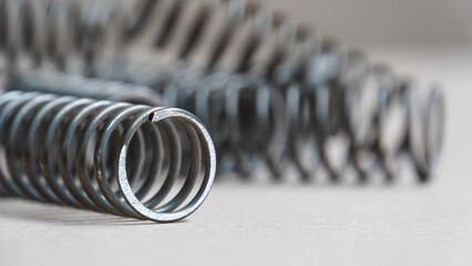 Coiled metal spring on metal surface, close-up view