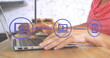 Image of network of connections with icons over woman using laptop